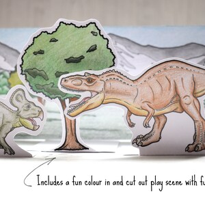Op de afbeelding: Een papieren knutselspel met twee dinosaurussen, een groene boom en een bergketen. De dinosaurussen zijn een bruine Tyrannosaurus Rex en een groene Triceratops. De sc&egrave;ne is ontworpen om in te kleuren en uit te knippen.