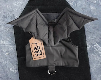Può includere: Costume da pipistrello nero per gatti con un'etichetta marrone che dice "All Cats Food".