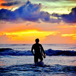 Sunrise Surfer in golven op het strand