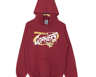 May include: Maroon hooded sweatshirt with a front pocket and the text "MINNESOTA GOPHERS" in yellow and white. The sweatshirt features a cartoon gopher mascot. The hoodie is displayed on a wooden hanger.