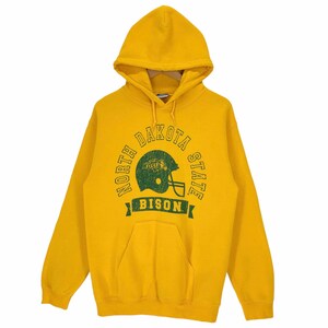 Può includere: Felpa con cappuccio giallo senape con cappuccio con coulisse e tasca a marsupio. La parte anteriore presenta una grafica verde consumata con le parole "NORTH DAKOTA STATE BISON" che circondano un casco da football.