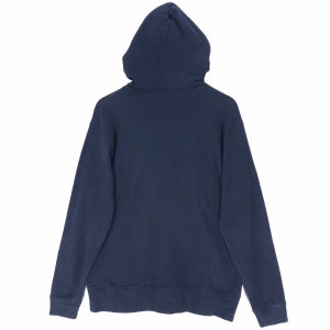 May include: A navy blue hoodie, viewed from the back, with the hood up. The sweatshirt has long sleeves and a drawstring hood. The cuffs and hem are ribbed. The material appears to be a soft, medium-weight fabric, suitable for cooler weather.