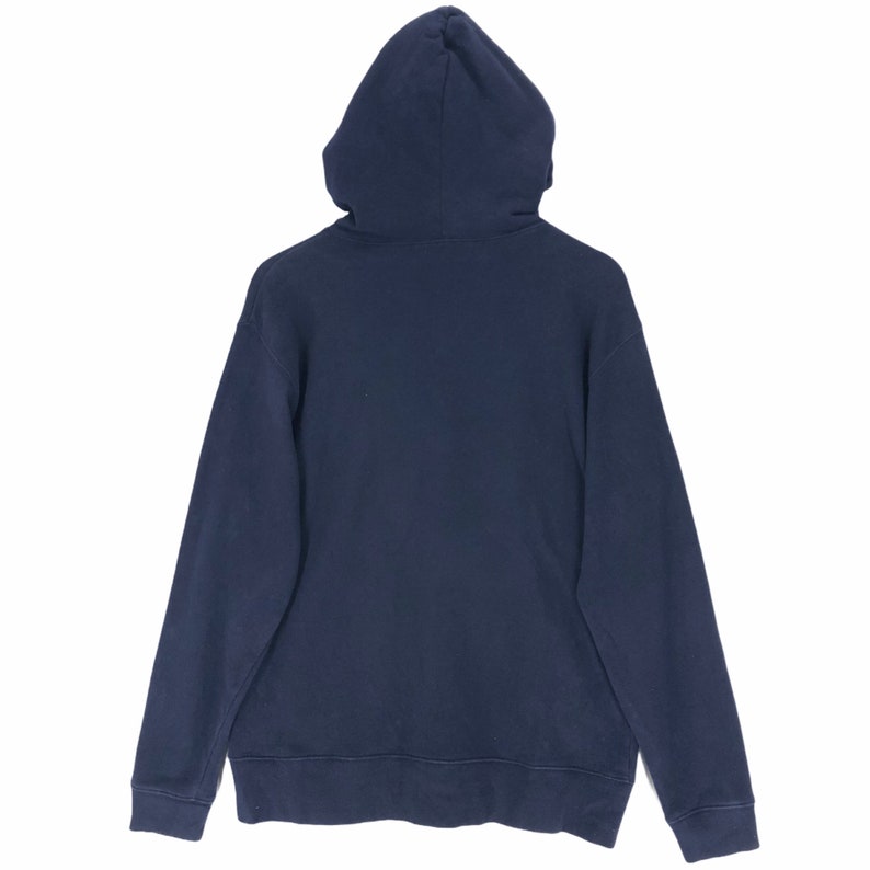 May include: A navy blue hoodie, viewed from the back, with the hood up. The sweatshirt has long sleeves and a drawstring hood. The cuffs and hem are ribbed. The material appears to be a soft, medium-weight fabric, suitable for cooler weather.