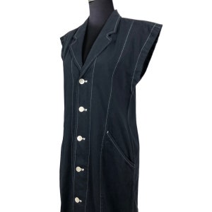 May include: A sleeveless black blazer-style dress with white vertical stitching and white buttons. The dress has a notched collar, a front pocket, and a tailored fit. The garment is displayed on a black mannequin.