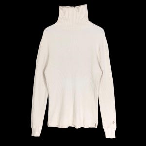 Puede incluir: Jersey de cuello alto color crema con textura de punto acanalado. El jersey de manga larga tiene un cuello alto y doblado y un pequeño detalle de flecha en el puño izquierdo. El jersey está hecho de un material suave y cómodo.