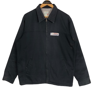 Puede incluir: Chaqueta negra con cremallera, cuello y parche con el logo de Vespa en el pecho. La chaqueta tiene dos bolsillos delanteros y un forro de color claro. El logo de Vespa es blanco y rojo.