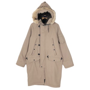 May include: A tan winter coat with a fur-lined hood. The coat has a button-up front, multiple pockets, and a relaxed fit. The hood is trimmed with faux fur. This warm coat is perfect for cold weather.