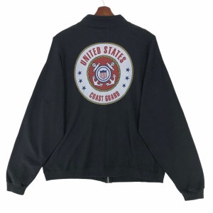 May include: Black zip-up sweatshirt with the United States Coast Guard emblem on the back. The emblem is a circular design with the words "United States Coast Guard" and a central crest with an anchor.