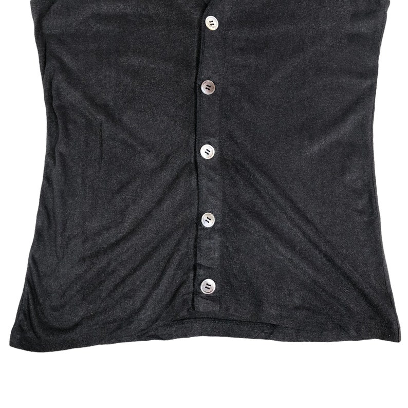 May include: A dark gray, button-down top with a scoop neck. The top has a series of six round, pearlescent buttons down the center. The fabric appears to be a soft, lightweight material.