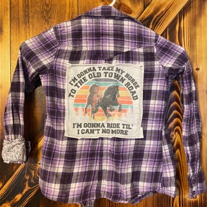 May include: Purple and white plaid flannel shirt with a patch on the back that says "I'm gonna take my horse to the old town road. I'm gonna ride til' I can't no more".