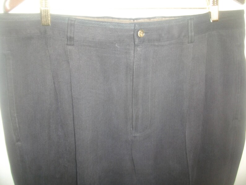 May include: A pair of black dress pants with a single button closure at the waist.