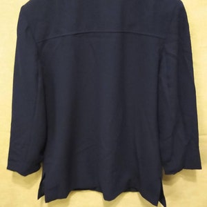 May include: A navy blue blazer with a long sleeve and a collared neckline.