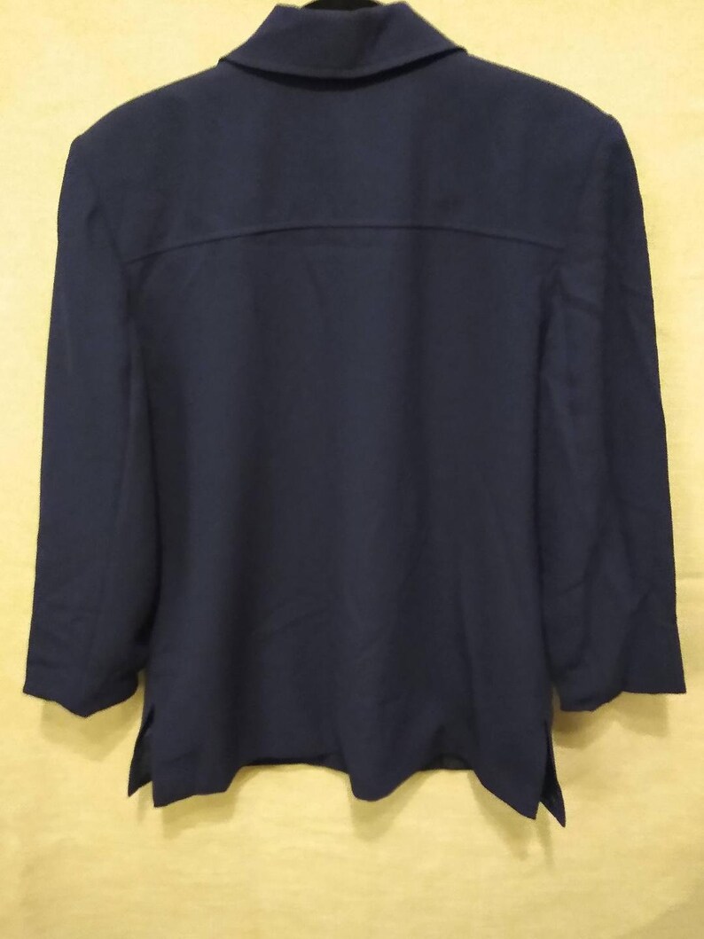 May include: A navy blue blazer with a long sleeve and a collared neckline.