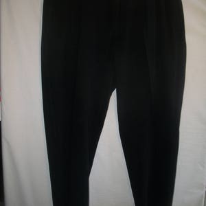May include: A pair of black dress pants with a flat front and a button closure.
