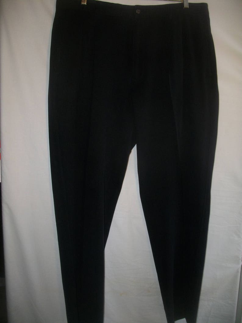 May include: A pair of black dress pants with a flat front and a button closure.