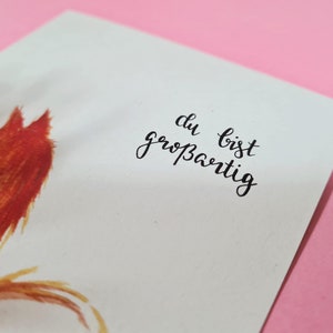 May include: A white card with a red fox illustration and the text "du bist gro&szlig;artig" in black calligraphy.