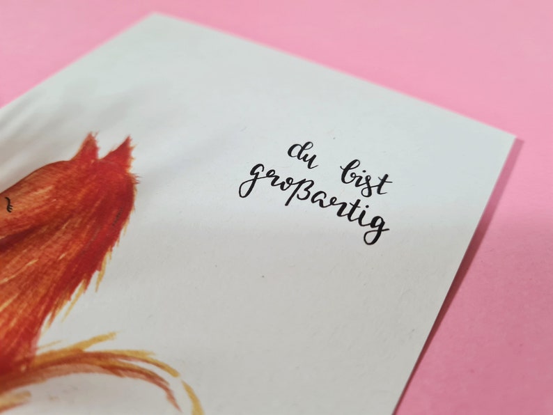 May include: A white card with a red fox illustration and the text "du bist gro&szlig;artig" in black calligraphy.