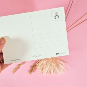 May include: A white postcard with a simple black and white illustration of a penguin on the top right corner. The postcard has lines for writing a message and the text "Lilies" and "www.lilies-berlin.com" at the bottom. The text "fb thelilies" is in the bottom right corner.