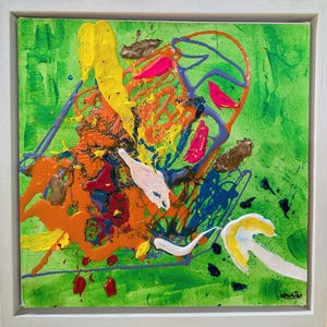 May include: Abstract artwork in a white frame. The painting uses a vivid palette of green, yellow, orange, pink, and blue. The paint is applied with bold strokes and splatters, creating a textured and dynamic composition.