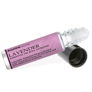 May include: Aromine essentials lavender essential oil roll-on blend in a clear glass bottle with a black cap. The label is pink and says "Lavender Essential Oil pre-diluted with Coconut Carrier Oil for easy and safe application anytime."