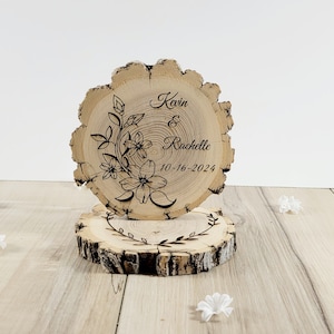 Centrotavola rustico per torta nuziale con fetta di legno e fiori incisi