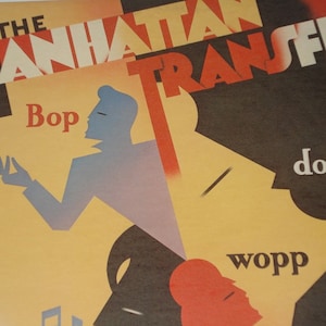 May include: A vintage poster with the text "THE MANHATTAN TRANSFER" in red and white. The poster features stylized figures in blue, red, and yellow, with the words "Bop," "doo-", and "wopp" incorporated into the design. The overall aesthetic is reminiscent of mid-century modern art.