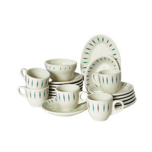 May include: A cream-colored ceramic dish set with a mid-century modern design. The set includes cups, saucers, bowls, and plates, all adorned with teal and gray vertical dashes. The plates are oval and round.