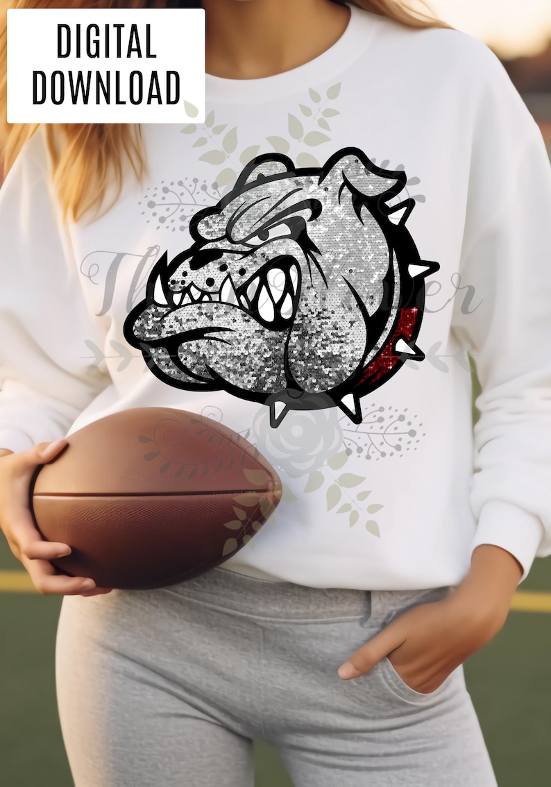 Peut inclure: Sweat-shirt blanc avec un motif de bouledogue d&eacute;taill&eacute;, d'aspect paillet&eacute;. Le bouledogue a des contours noirs, un col rouge et des pointes blanches. Les mots "T&Eacute;L&Eacute;CHARGEMENT NUM&Eacute;RIQUE" sont dans un rectangle blanc. Un ballon de football marron est tenu dans les mains.
