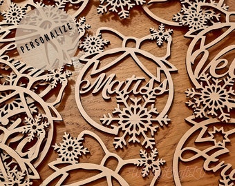 May include: Wooden Christmas ornaments with snowflake designs and personalized names, including "Matiss" and "Helen".