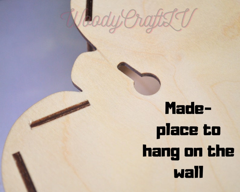 May include: Close-up of a light wood cutout with a hole for hanging. The text "Made-place to hang on the wall" is printed on the wood.