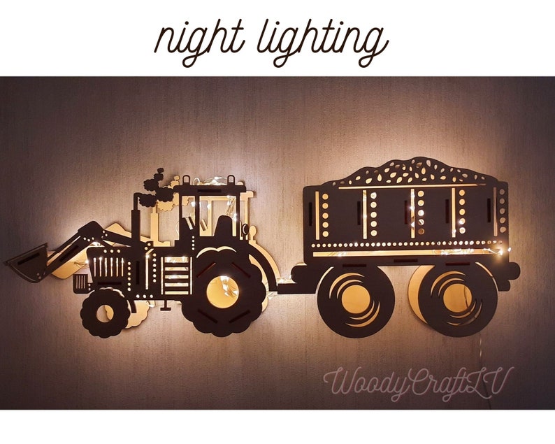 May include: A wooden tractor and trailer night light with a black silhouette and a string of lights inside. The trailer is filled with a grain. The text "night lighting" is above the tractor and "Woody Crafts LV" is below the trailer.