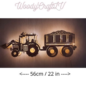 May include: A black wooden silhouette of a tractor with a trailer, illuminated with warm white lights. The tractor is 7.68 inches tall and 22 inches wide.