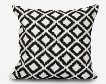 May include: Black and white geometric patterned cushion with a diamond design.