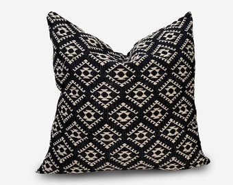May include: Black and cream throw pillow with a geometric pattern.