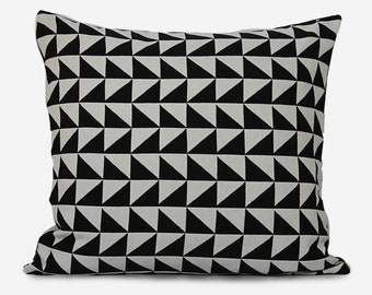 Könnte beinhalten: Schwarzes und weißes geometrisches Kissen mit Muster. Das Kissen hat ein sich wiederholendes Muster aus Dreiecken.
