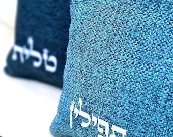 May include: Two blue fabric pouches with white Hebrew text. The larger pouch has the word "שלום" and the smaller pouch has the word "דבר" on it.