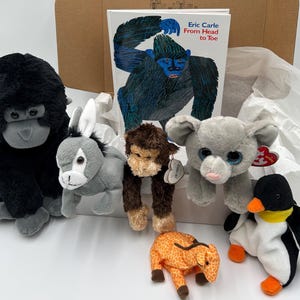 May include: A collection of plush animal toys, including a gorilla, donkey, monkey, elephant, giraffe, and penguin. A children's book titled "Eric Carle From Head to Toe" is also present. The toys are in various colors and sizes.