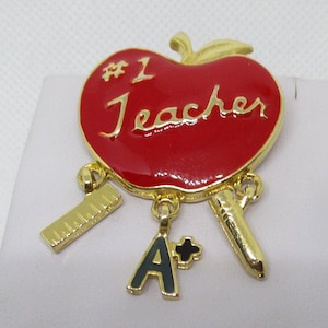 Vintage REN #1 docentenbroche: emaille appel, liniaal, potloodbedels