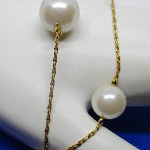 May include: A gold chain bracelet with four white pearls. The pearls are different sizes and are evenly spaced along the chain.