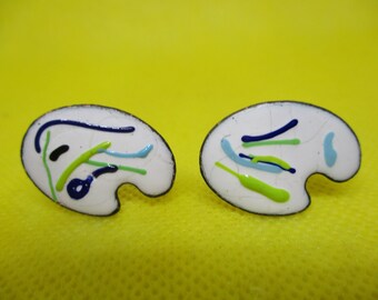 May include: A pair of silver-toned earrings shaped like artist's palettes with colourful enamel paint details in blue, green, and white.