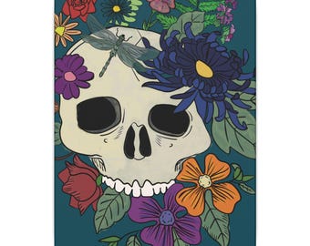 May include: A white skull with a dragonfly perched on top, surrounded by colorful flowers, including purple, blue, orange, and red. The background is a teal blue.