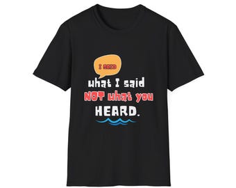 Puede incluir: Camiseta negra con la frase "I said what I said NOT what you HEARD." El texto es en blanco y rojo, con un bocadillo. La camiseta tiene cuello redondo y mangas cortas.