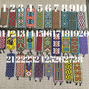 May include: Twenty-eight colorful beaded bracelets with geometric patterns. The bracelets are numbered 1 through 28.