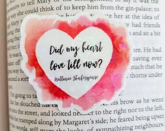 Peut inclure: Un autocollant en forme de cœur rose et blanc avec la citation "Did my heart love till now?" de William Shakespeare. L'autocollant a un design ressemblant à une aquarelle.