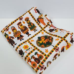 May include: White fabric with a repeating pattern of colourful figures and fruit. The figures are wearing traditional clothing and holding objects. The fruit is arranged in a basket.