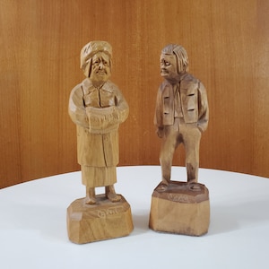 Pair Caron Flat Plane Wood Carvings of an Old Man and Old Woman - Signed Caron - 1960s