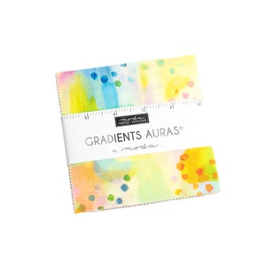 May include: A pack of fabric squares with a watercolor-style design featuring abstract shapes and dots in shades of yellow, blue, pink, and green. The fabric squares are labeled "Gradients Auras" by Moda.
