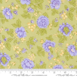May include: A green fabric with a repeating pattern of purple flowers and yellow accents. The fabric is shown with a ruler for scale.