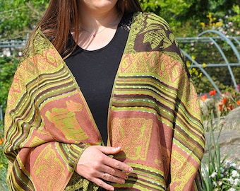 May include: A green and brown shawl with a geometric pattern and fringe. The shawl is made of a soft, lightweight fabric and is perfect for layering.