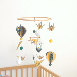 Origami baby mobile with airplane and hot air balloon, vintage style.